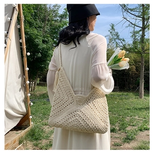 Detail view of cream crochet shoulder bag with geometric woven texture and tassel accents