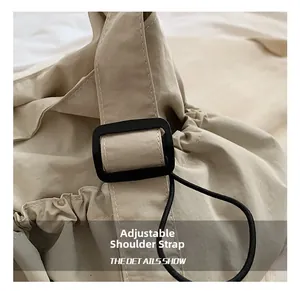 Detail view of the adjustable strap buckle on a minimalist nylon drawstring bucket bag