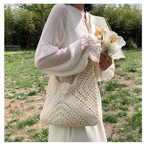 Detailed macro view of beige crochet knitted shoulder bag with geometric hollow pattern