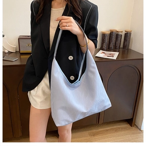 Gros plan du sac cabas bleu clair avec texture micro-rides dans un décor intérieur