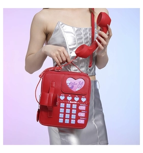 Detail shot of vintage red telephone bag featuring heart-shaped window and creative handset
