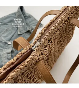 Detail of a handmade straw tote bag featuring a smooth metal zipper and leather strap