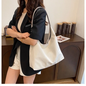 Détail d'un grand sac hobo en cuir blanc montrant sa texture et sa capacité spacieuse