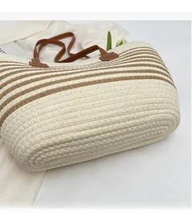 Close-up of woven tote bag featuring striped straw texture and brown leather handles