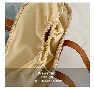 Detail showing the straw woven texture and drawstring fabric lining of the handbag