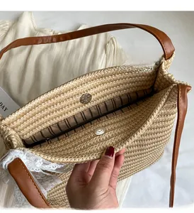 Détail du sac en paille avec fermoir magnétique, doublure rayée et poche zippée interne