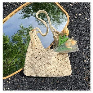 Chic cream white hand-knitted crochet shoulder bag featuring long tassels and woven straps