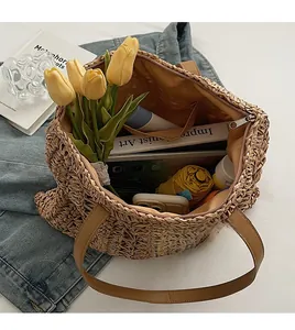 Spacious interior of woven straw tote bag with brown leather handles and inner zipper pocket
