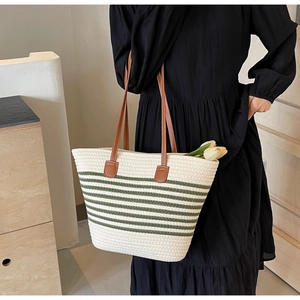Detailed close-up of a handwoven striped tote bag with leather straps and spacious interior