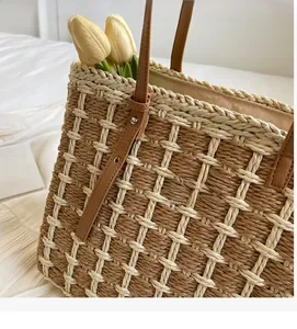 Détail d'un sac à main tissé à carreaux avec poignées en cuir marron et fleurs à l'intérieur