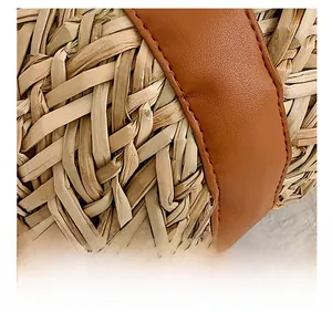 Detailed close-up of straw woven texture with high-quality brown leather strap stitching