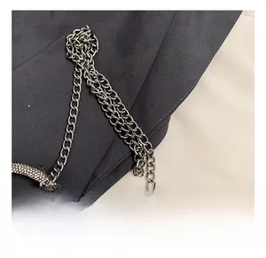 Detail of silver metal chain strap and luxury rhinestone-studded curved buckle hardware
