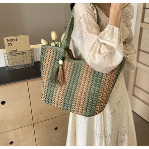 Detail of woven tote bag with green stripes, wooden bead tassels, and large capacity