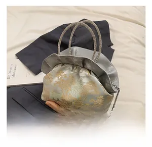 Detail showing gold landscape print and elegant ruffled closure on the PU leather handbag