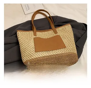 Close-up of woven straw texture and premium brown PU leather stitching on tote bag