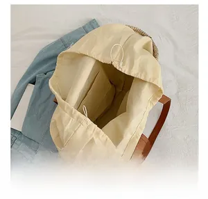 Detail view of woven straw tote bag featuring inner canvas lining and drawstring closure