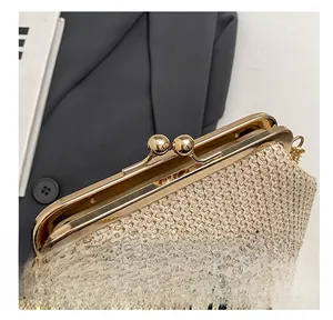 Détail d'un sac à main en paille tressée avec fermoir doré et broderie noire élégante