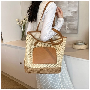 Close-up of the textured straw weave and brown PU leather pocket on this large tote bag