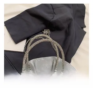 Detailed close-up of crystal-encrusted ring handles on a luxury silver crossbody bag