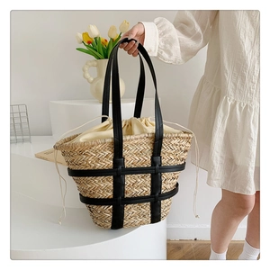 Detail of woven straw handbag featuring black leather trim and secure beige drawstring liner
