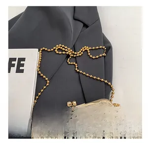 Détail du sac à paillettes beige avec broderie noire et chaîne dorée à perles