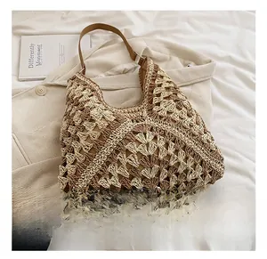 Detail of woven beach tote showing brown leather strap and contrast geometric patterns