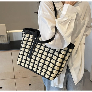 Détail du cabas en paille tressée avec motif à carreaux noir et blanc et fines anses en cuir