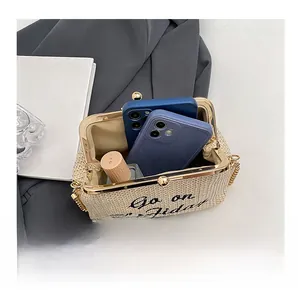 Détail de l'intérieur d'une pochette en paille contenant des téléphones et un rouge