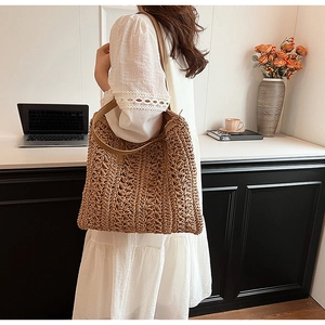 Detail of woven straw shoulder bag with leather handles and natural hollow texture