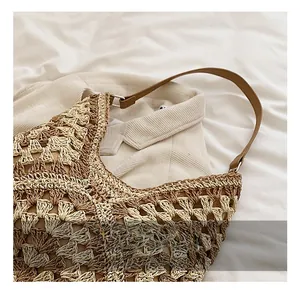 Detail of hand-woven hollow knit tote bag with gradient tones and brown leather handle