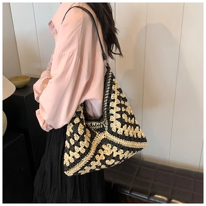 Macro shot of hand-crocheted tote bag with vintage black and beige floral knit patterns