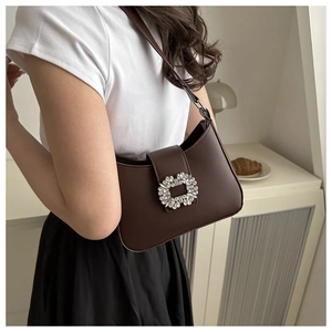 Detail of a dark brown PU leather shoulder bag with a luxury square rhinestone buckle