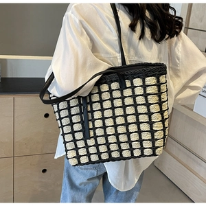 Détail du sac cabas en paille tissée à carreaux avec fines bandoulières noires