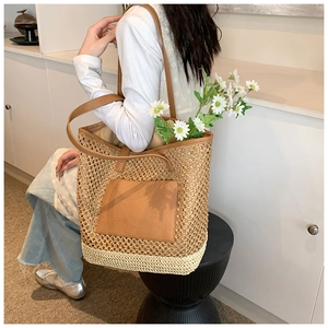 Detail of hand-woven straw tote bag with brown PU leather pocket and mesh design