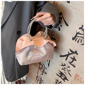 Detailed embroidery of Chinese pavilions on a pink pleated silk cloud crossbody bag