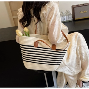 Detail of woven rope tote bag with black stripes, leather handles and hand-made style