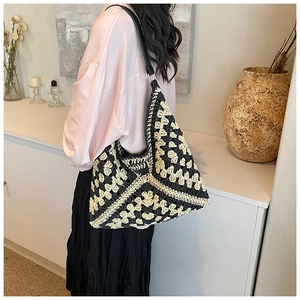 Detail view of large hand-knitted crochet tote bag with contrast black and beige patterns