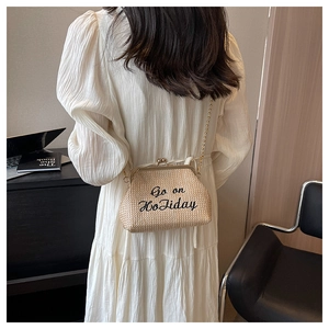Détail du sac en paille avec broderie Go on Holiday et bandoulière dorée