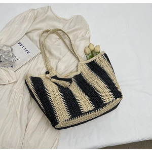Chic woven straw tote bag with black and beige stripes and a decorative tassel