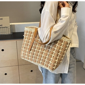 Détail du sac cabas en paille tissée avec motif à carreaux et bandoulière en cuir
