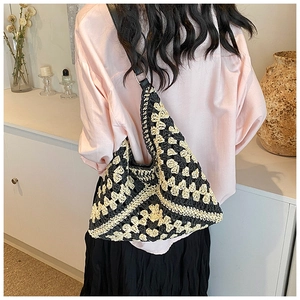 Detail of hand-crocheted shoulder bag with black and white geometric retro patterns