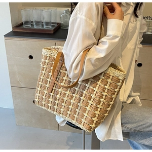 Détail du sac cabas en paille tressée avec texture quadrillée et bandoulière en cuir
