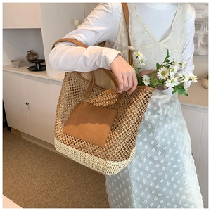 Detail showing handwoven straw texture and brown PU leather pocket on the tote bag