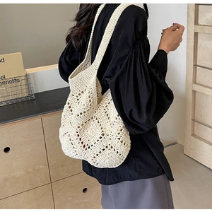 Détail d'un sac hobo en crochet crème avec motifs en maille ajourée style bohème