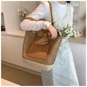 Handmade straw tote bag with brown PU pocket and shoulder straps shown on a model