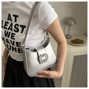 Detail of silver metallic PU shoulder bag with iconic crystal square buckle on strap