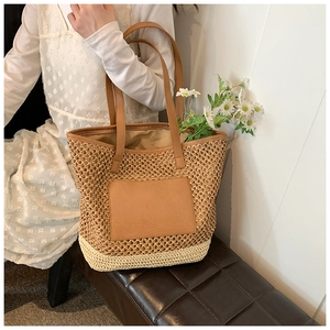 Close-up of woven straw tote bag with brown PU leather pocket and stylish color stitching