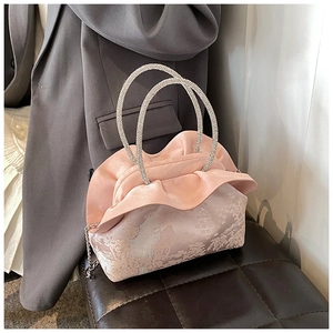 Close-up of pink retro PU handbag featuring floral patterns and ruffle trim details