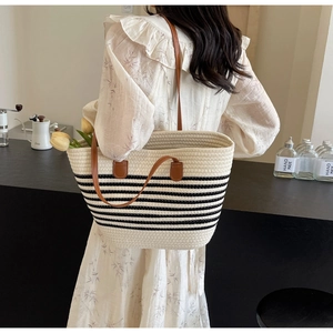 Close-up of the woven texture and premium brown leather handles on this stylish tote bag