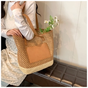 Straw tote bag with brown faux leather straps shown on model in a bohemian style setting